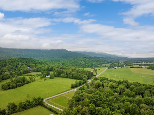 aerial view of sparsely populated area featuring a mountainous background and a heavily wooded area