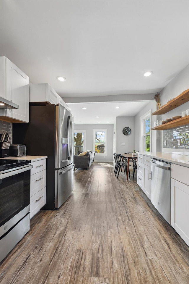 618 Hamilton Ave, Chattanooga, TN 37405 - kitchen featuring stainless steel appliances, wood finished floors, light countertops, white cabinets, and decorative backsplash