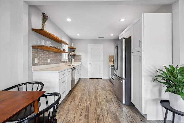 618 Hamilton Ave, Chattanooga, TN 37405 - kitchen with appliances with stainless steel finishes, a sink, wood finished floors, light countertops, and open shelves