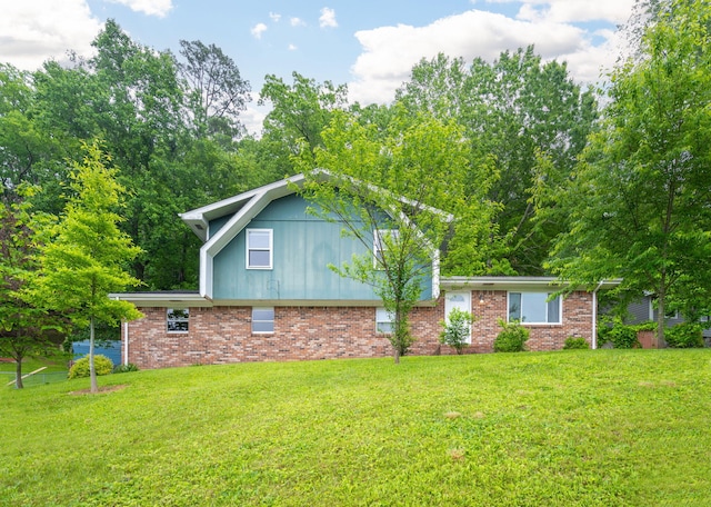 view of side of home featuring a yard and brick siding