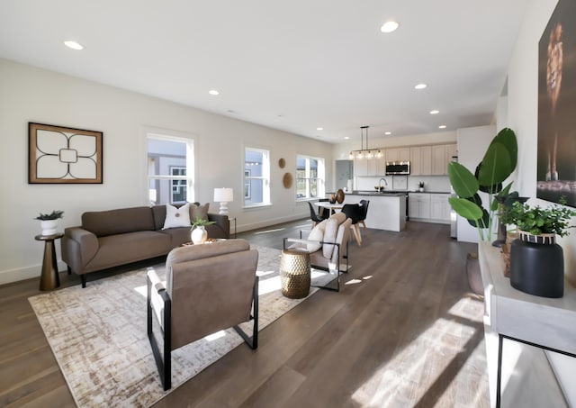 living area with dark wood-type flooring, baseboards, and recessed lighting