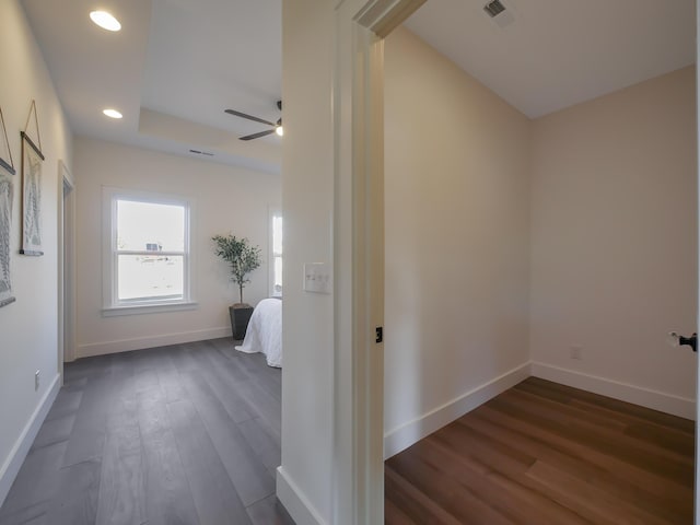 corridor with visible vents, baseboards, dark wood-type flooring, and recessed lighting