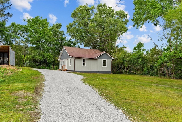 view of front facade featuring metal roof, a front yard, crawl space, and gravel driveway