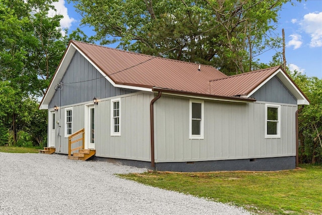 view of property exterior with metal roof, crawl space, and entry steps