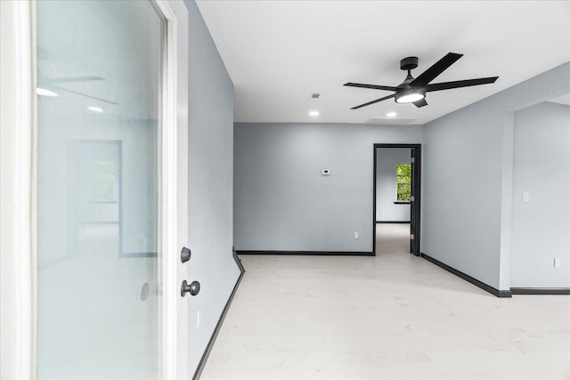 spare room with a ceiling fan, baseboards, and finished concrete floors