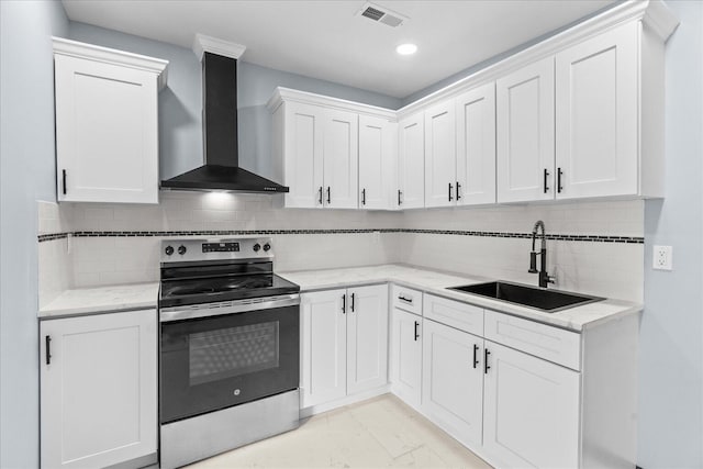 kitchen featuring a sink, stainless steel electric stove, visible vents, wall chimney exhaust hood, and white cabinetry