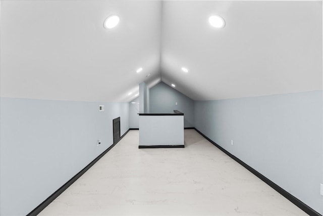 additional living space featuring lofted ceiling, baseboards, marble finish floor, and recessed lighting