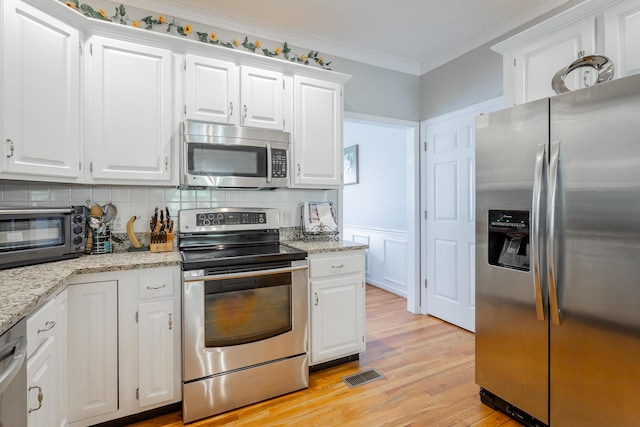 1572 Windstone Dr, Ringgold, GA 30736 - kitchen with appliances with stainless steel finishes, crown molding, light wood finished floors, white cabinets, and tasteful backsplash