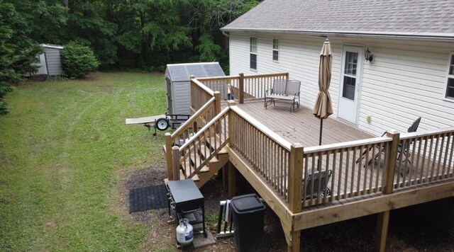 deck with stairway, a storage shed, an outbuilding, and a lawn