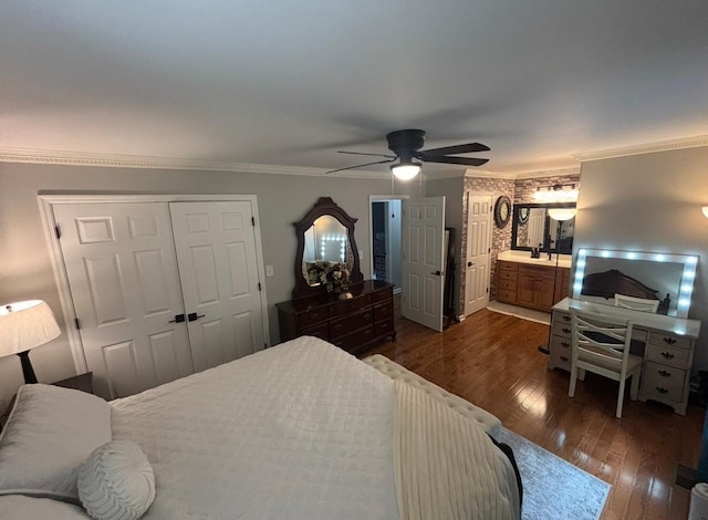 bedroom with crown molding, ceiling fan, dark wood-style floors, and a closet
