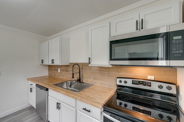 9 Longstreet Rd, Rossville, GA 30741 - kitchen with appliances with stainless steel finishes, a sink, white cabinets, light wood-type flooring, and ornamental molding