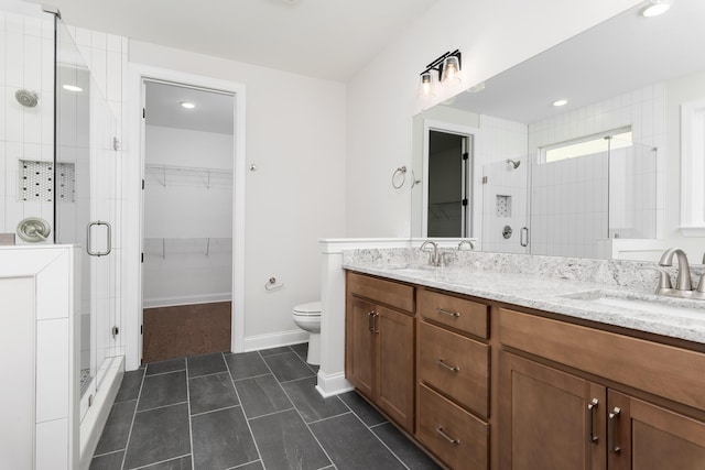 full bath with a stall shower, a walk in closet, double vanity, tile patterned floors, and toilet