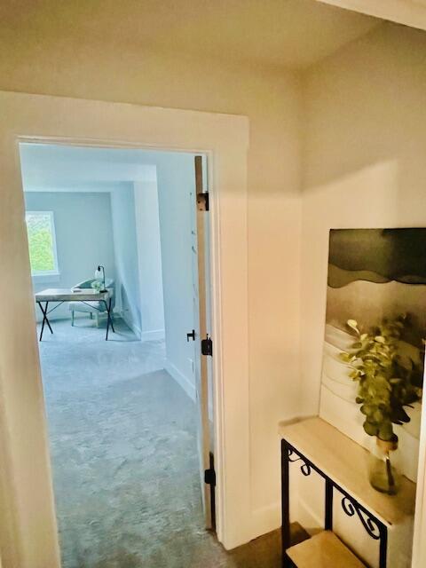 corridor featuring carpet flooring and baseboards