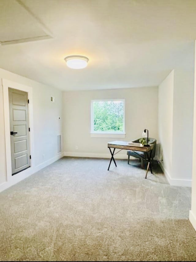 carpeted spare room featuring baseboards