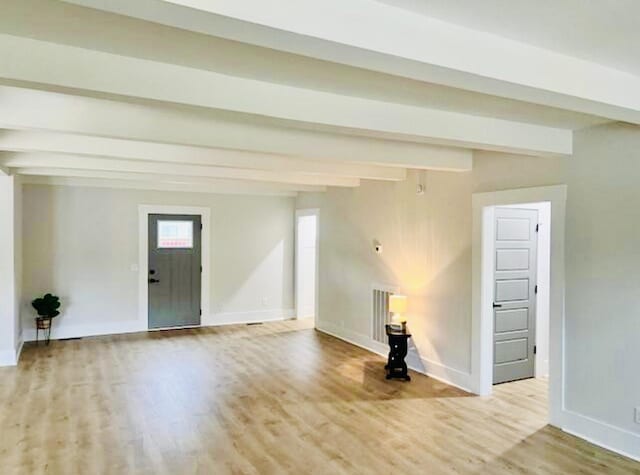 foyer featuring beam ceiling, baseboards, and wood finished floors
