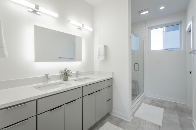 full bathroom with baseboards, a shower stall, and a sink