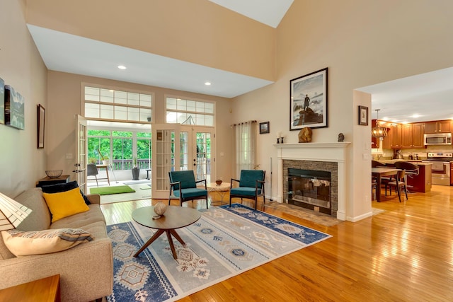 802 Creek Overlook Rd, Chattanooga, TN 37415 - living room with light wood-style floors, a high ceiling, a stone fireplace, recessed lighting, and french doors