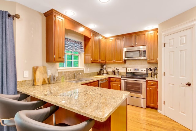 802 Creek Overlook Rd, Chattanooga, TN 37415 - kitchen with appliances with stainless steel finishes, a sink, a kitchen breakfast bar, a peninsula, and light stone countertops