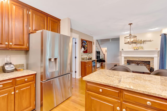 802 Creek Overlook Rd, Chattanooga, TN 37415 - kitchen with stainless steel fridge, brown cabinetry, and a fireplace