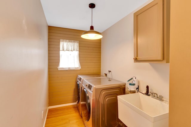 802 Creek Overlook Rd, Chattanooga, TN 37415 - washroom with wood walls, baseboards, washing machine and dryer, light wood finished floors, and cabinet space