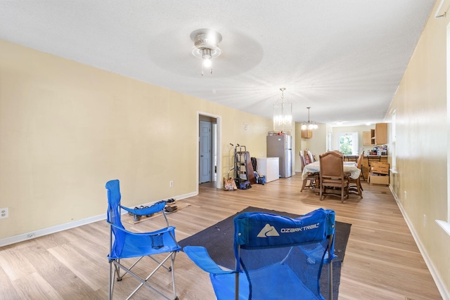 2121 Davenport St, Chattanooga, TN 37406 - sitting room featuring a chandelier, light wood finished floors, a ceiling fan, and baseboards