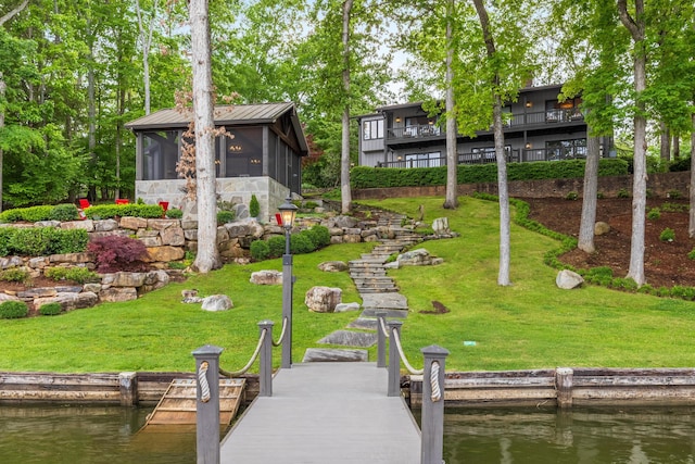 view of dock featuring a water view and a lawn