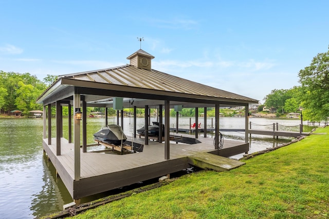 dock area featuring a water view, boat lift, and a yard