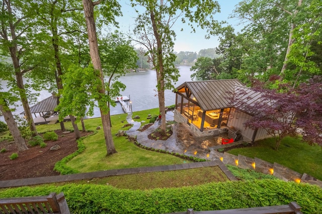 surrounding community with a water view, a yard, and a boat dock