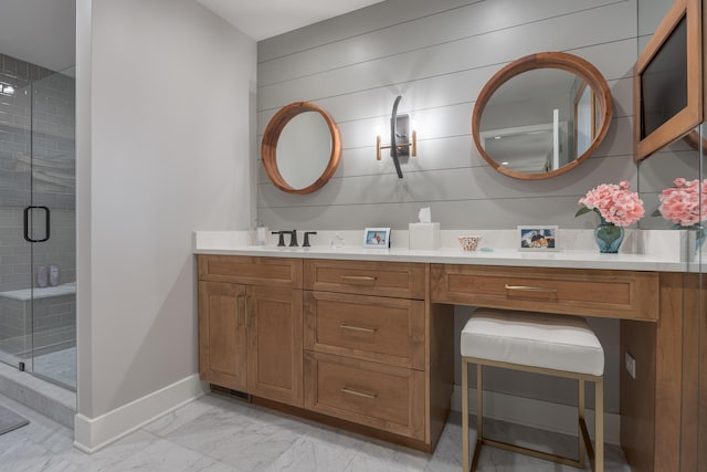 bathroom featuring vanity, a stall shower, marble finish floor, and baseboards