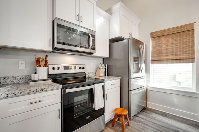 68 Rock Bridge Dr, Ringgold, GA 30736 - kitchen featuring stainless steel appliances, light wood-style floors, white cabinetry, baseboards, and light stone counters