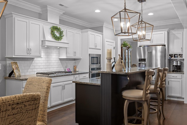 7258 Grey Hawk Trl, Signal Mountain, TN 37377 - kitchen featuring appliances with stainless steel finishes, a kitchen island, white cabinets, dark stone counters, and a breakfast bar