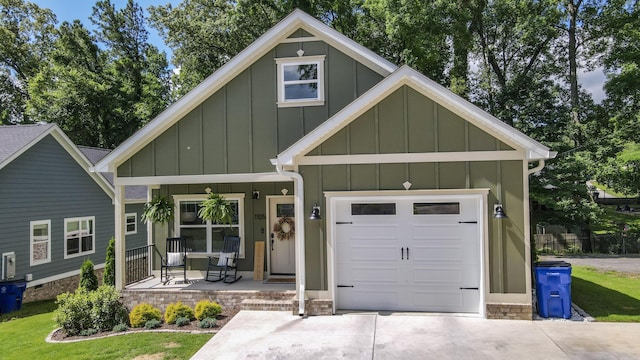 1105 18th St NW, Cleveland, TN 37311 - view of front facade featuring board and batten siding, covered porch, driveway, an attached garage, and a front lawn