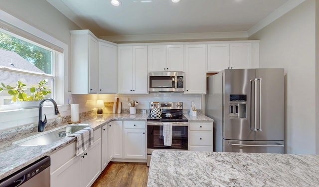 1105 18th St NW, Cleveland, TN 37311 - kitchen featuring appliances with stainless steel finishes, a sink, white cabinetry, ornamental molding, and light stone counters