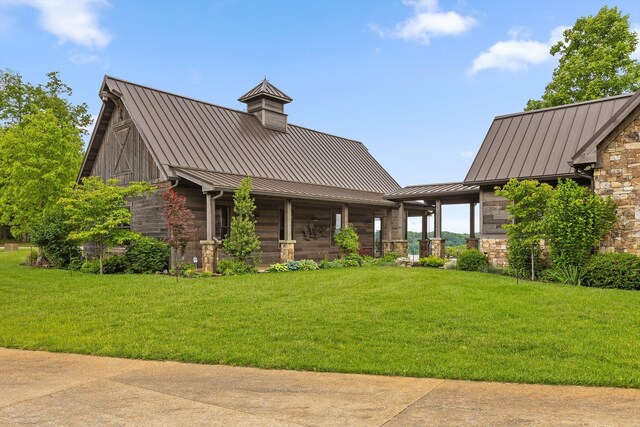 6835 Jasper Highlands Blvd, Jasper, TN 37347 - back of property featuring a standing seam roof, metal roof, stone siding, and a lawn