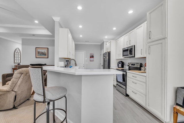 7861 Laurelton Dr, Chattanooga, TN 37421 - kitchen featuring stainless steel appliances, open floor plan, a kitchen bar, recessed lighting, and ornamental molding