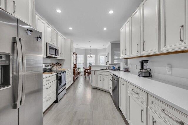 7861 Laurelton Dr, Chattanooga, TN 37421 - kitchen featuring appliances with stainless steel finishes, crown molding, white cabinetry, light countertops, and recessed lighting
