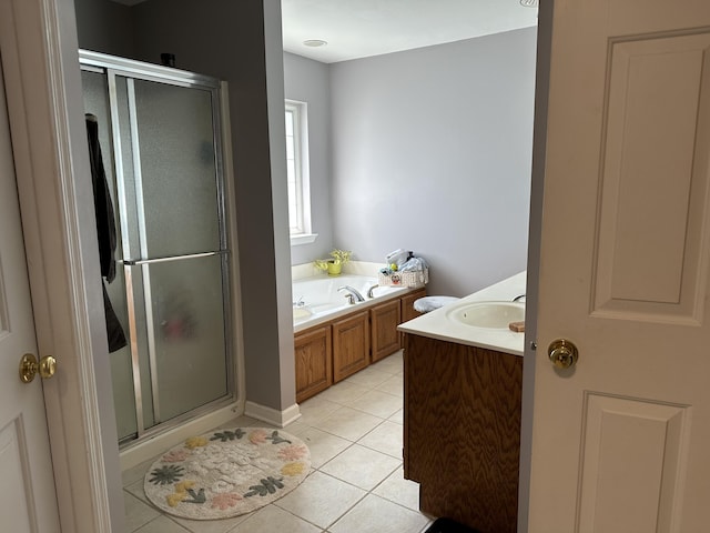 bathroom featuring a stall shower, a garden tub, tile patterned flooring, and vanity