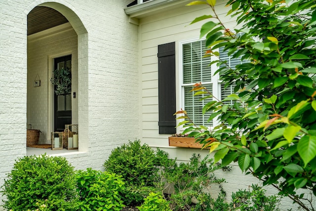 doorway to property featuring brick siding