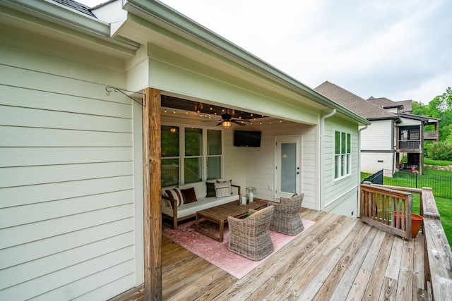 wooden terrace with ceiling fan, fence, and an outdoor hangout area