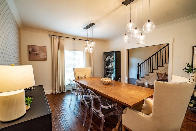 dining area featuring a chandelier, dark wood finished floors, baseboards, crown molding, and wallpapered walls
