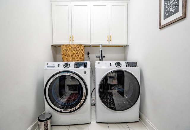 laundry room featuring cabinet space, washer and clothes dryer, and baseboards