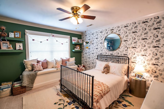 bedroom with crown molding, ceiling fan, carpet floors, wallpapered walls, and baseboards