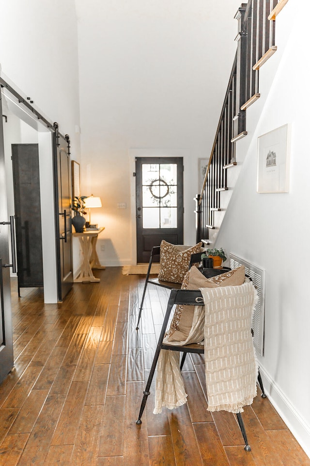 9405 Peppy Branch Trl, Apison, TN 37302 - foyer entrance with a barn door, hardwood / wood-style flooring, a towering ceiling, stairway, and baseboards