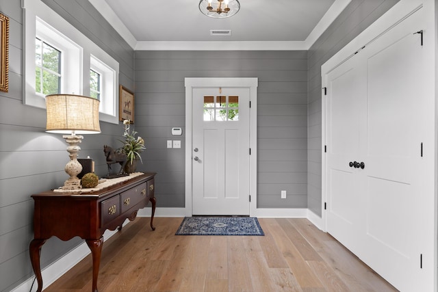 entrance foyer featuring light wood-type flooring, baseboards, and ornamental molding