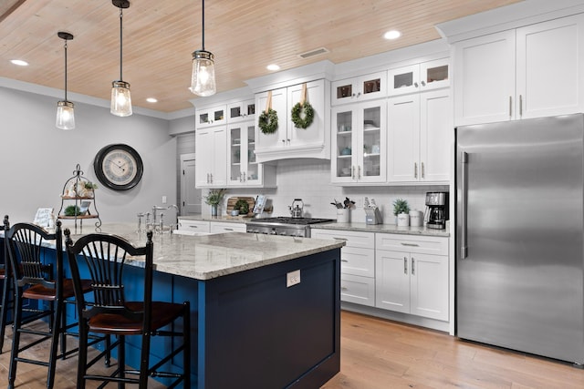 kitchen with stainless steel built in refrigerator, wood ceiling, a breakfast bar area, light stone counters, and hanging light fixtures