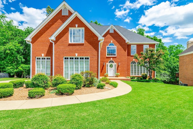 view of front of home with a front lawn and brick siding