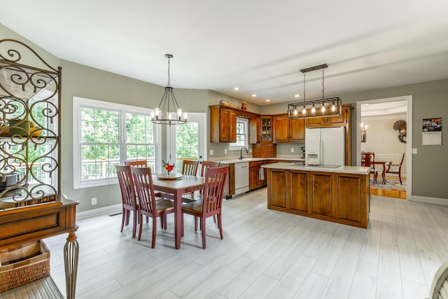 dining area featuring a chandelier, baseboards, recessed lighting, and light wood-style floors