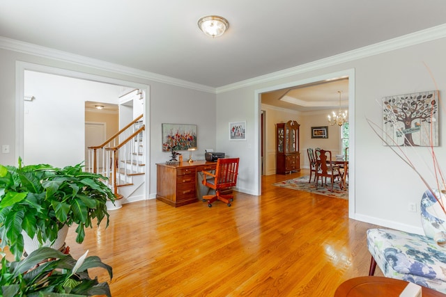 office space with light wood-style floors, ornamental molding, a chandelier, and baseboards