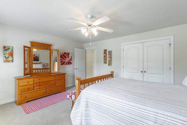 carpeted bedroom featuring a closet, baseboards, and ceiling fan