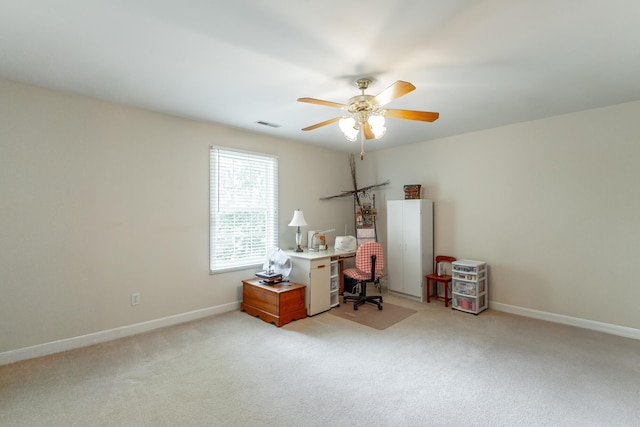 home office featuring a ceiling fan, light carpet, and baseboards